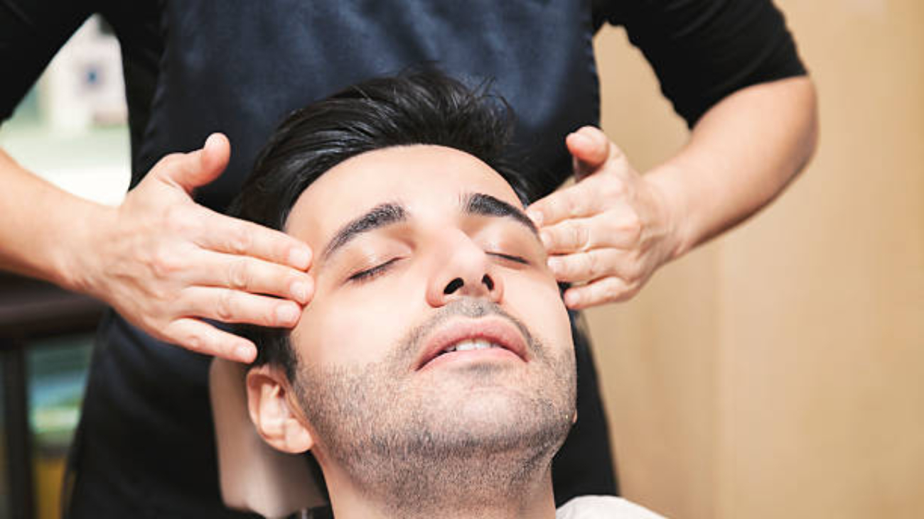Young Turkish man getting skin care and facial massage - male beauty